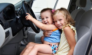 Funny young children are driving big cars