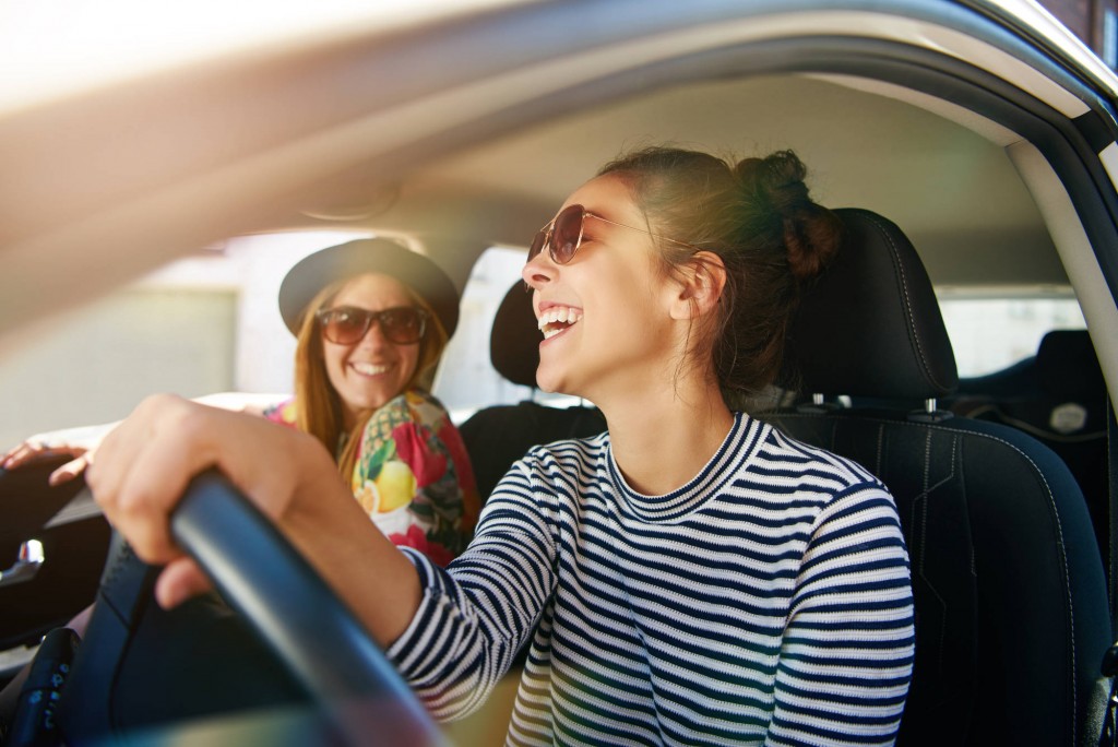 Smiling,Happy,Young,Woman,Giving,Her,Friend,A,Lift,In