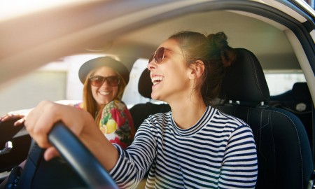 Smiling,Happy,Young,Woman,Giving,Her,Friend,A,Lift,In